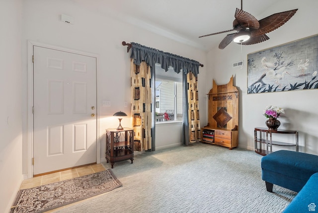 living area with ceiling fan, carpet floors, visible vents, and baseboards