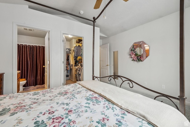 bedroom with a walk in closet, lofted ceiling, a closet, visible vents, and ensuite bath