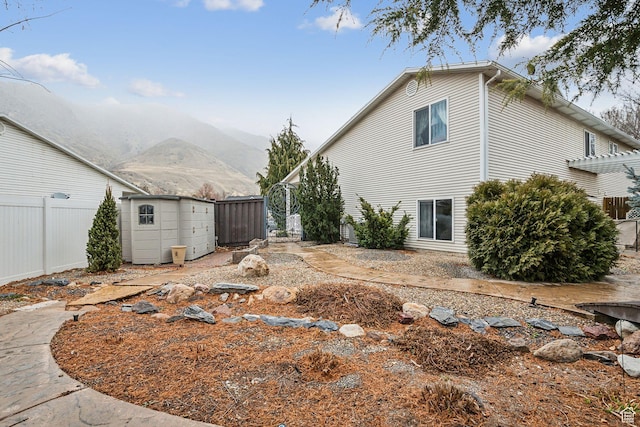 exterior space featuring an outbuilding, fence, a shed, a mountain view, and a pergola