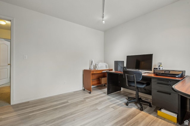 office with light wood-style floors, baseboards, and rail lighting
