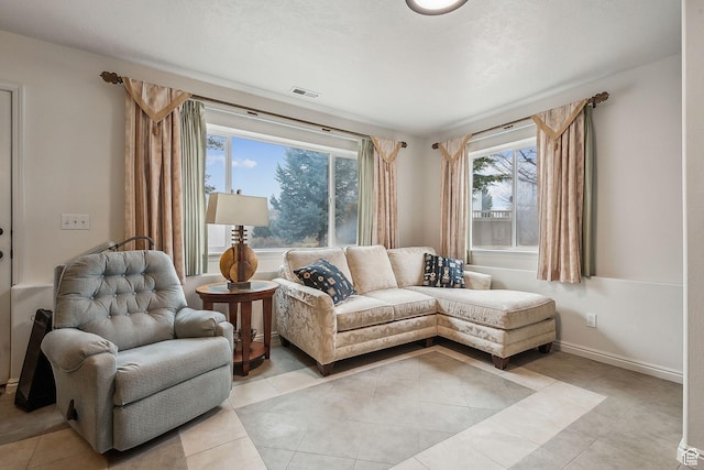 living area with light tile patterned floors, baseboards, and visible vents