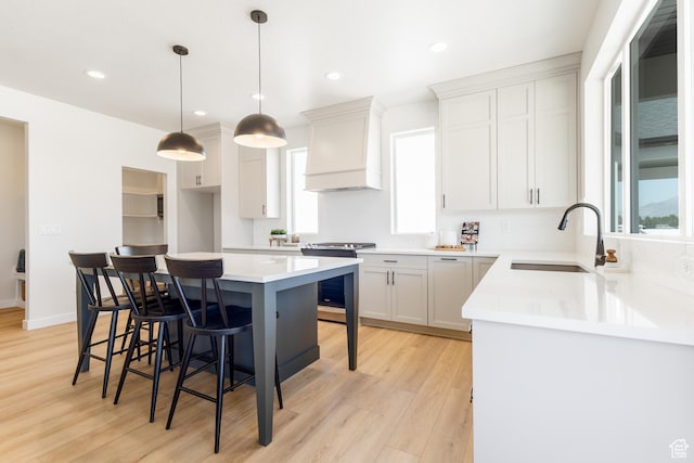 3062 N 2875 W Unit 24, Plain City, UT 84404 - kitchen with a sink, custom exhaust hood, light wood-type flooring, gas stove, and recessed lighting