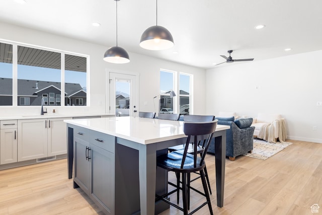 3062 N 2875 W Unit 24, Plain City, UT 84404 - kitchen featuring a sink, light wood-type flooring, a breakfast bar, ceiling fan, and recessed lighting
