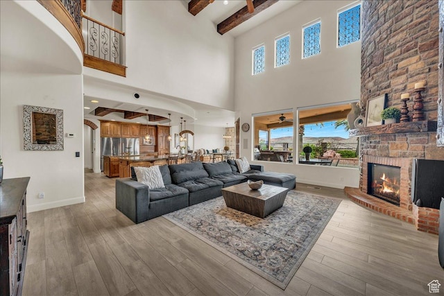 living room featuring a large fireplace, light wood-type flooring, and plenty of natural light