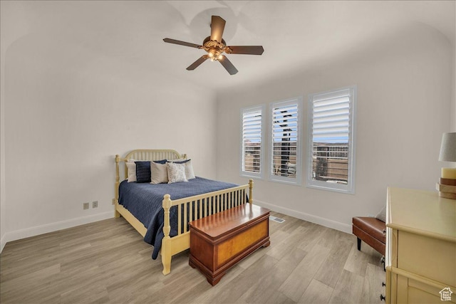 bedroom with light wood-style floors, visible vents, ceiling fan, and baseboards