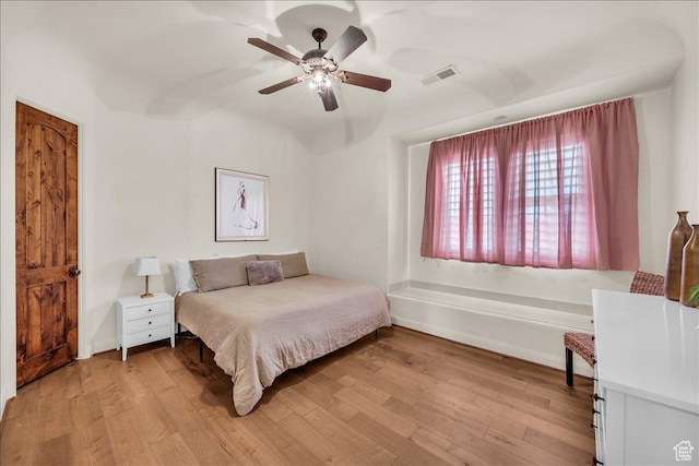 bedroom with light wood-style flooring, visible vents, ceiling fan, and baseboards