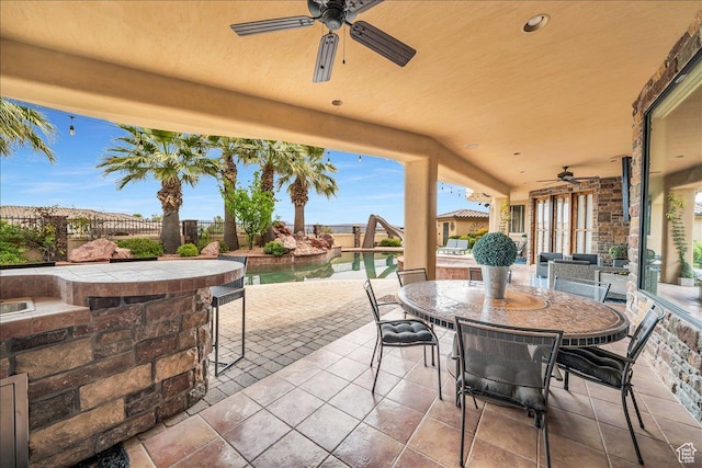 view of patio / terrace featuring french doors, outdoor dining space, fence, ceiling fan, and an outdoor pool