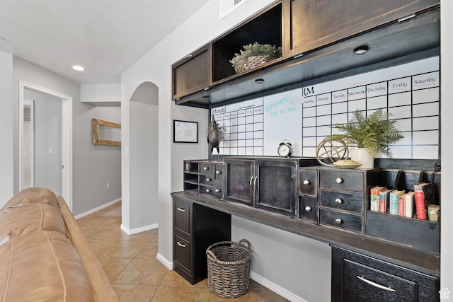 1808 W Fox Bay Dr Unit B304, Heber City, UT 84032 - bar with arched walkways, a textured ceiling, light tile patterned flooring, visible vents, and baseboards