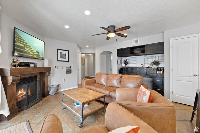 1808 W Fox Bay Dr Unit B304, Heber City, UT 84032 - living room with arched walkways, visible vents, a ceiling fan, a glass covered fireplace, and a textured ceiling