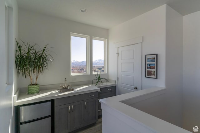 bar with a sink, wood finished floors, and freestanding refrigerator