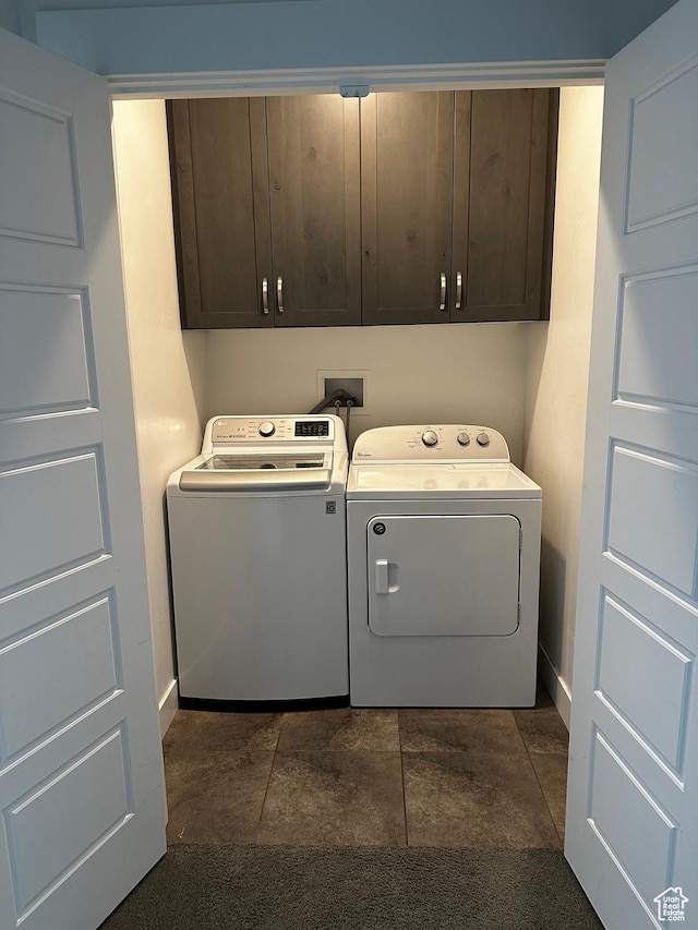 washroom featuring cabinet space, washer and dryer, and baseboards