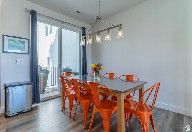 dining space featuring wood finished floors, visible vents, and baseboards