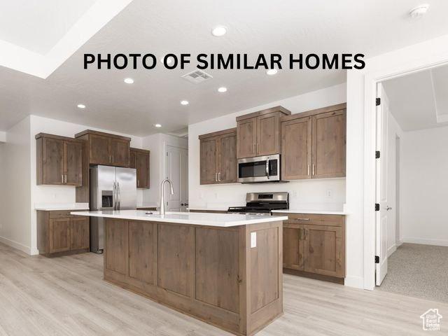kitchen featuring stainless steel appliances, light countertops, visible vents, and a sink