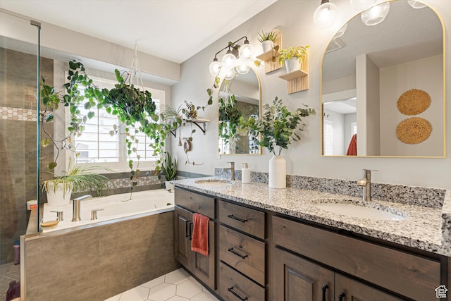 bathroom with double vanity, tiled shower, a garden tub, and a sink