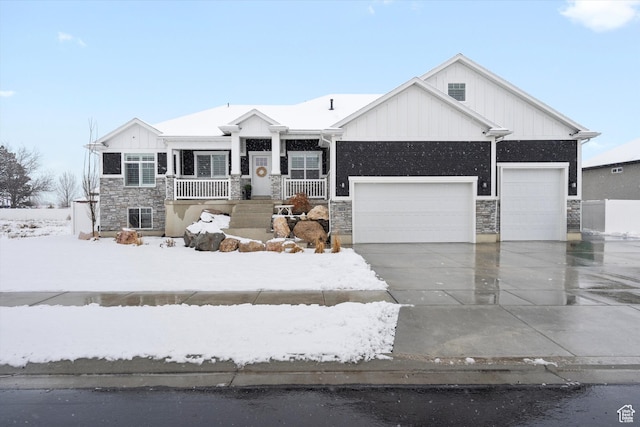 view of front of house with a garage, stone siding, board and batten siding, and driveway
