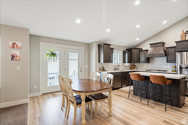 dining space featuring lofted ceiling, recessed lighting, baseboards, and light wood finished floors