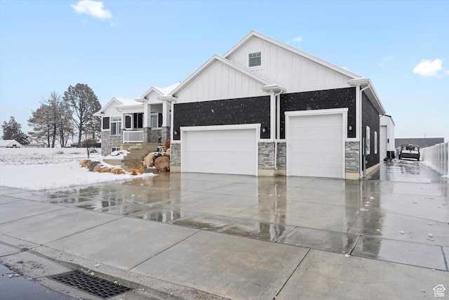 view of front facade with stone siding, board and batten siding, concrete driveway, and an attached garage