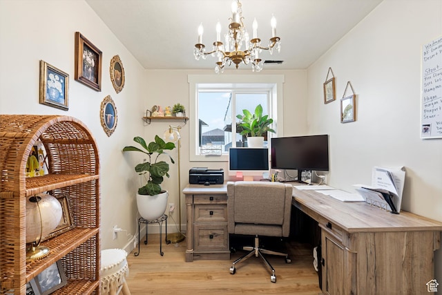 home office with a notable chandelier, baseboards, and light wood-style floors