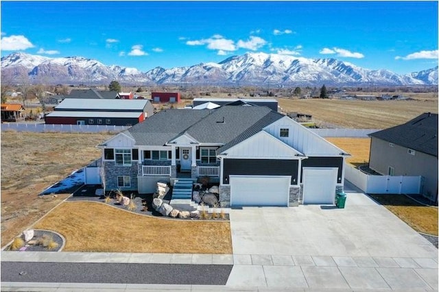 view of front of home with a mountain view, stone siding, and an attached garage