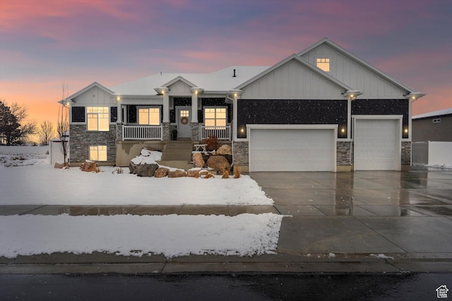 view of front of home with driveway, stone siding, a porch, board and batten siding, and an attached garage
