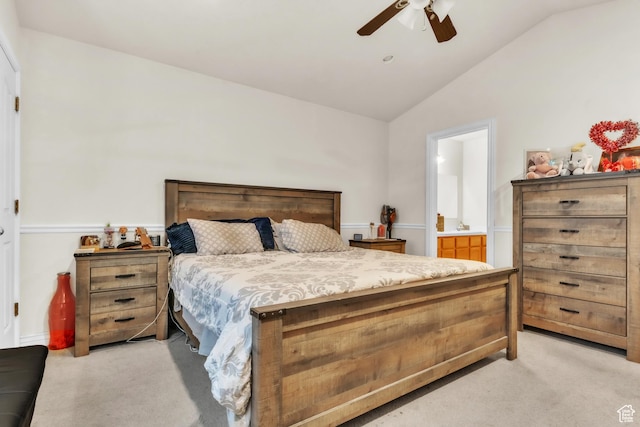 bedroom with light carpet, ceiling fan, vaulted ceiling, and ensuite bathroom