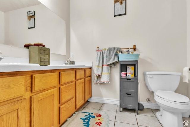 bathroom featuring baseboards, vanity, toilet, and tile patterned floors