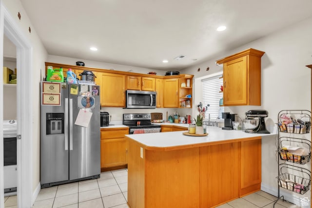 kitchen featuring appliances with stainless steel finishes, light countertops, a peninsula, and light tile patterned floors