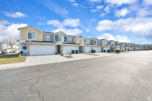 6512 S 390 E, South Weber, UT 84405 - view of property featuring a garage, concrete driveway, stone siding, and a residential view