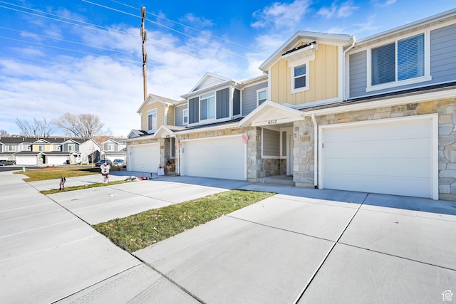 6512 S 390 E, South Weber, UT 84405 - townhome / multi-family property with concrete driveway, board and batten siding, a garage, a residential view, and stone siding