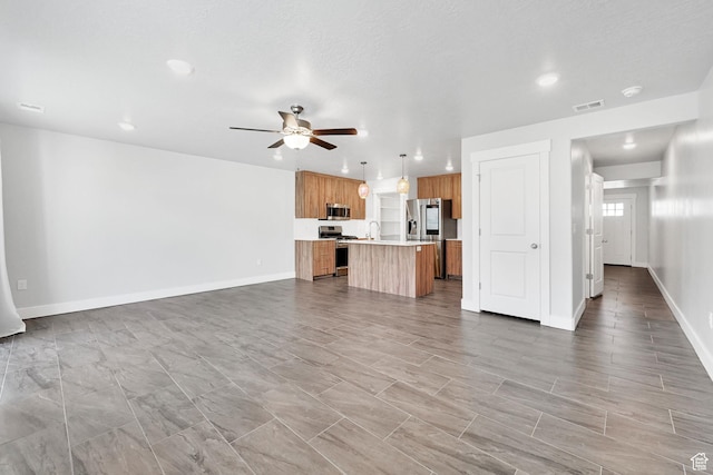 6512 S 390 E, South Weber, UT 84405 - unfurnished living room featuring visible vents, baseboards, ceiling fan, a sink, and recessed lighting