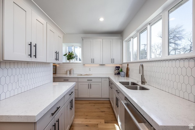 kitchen with dishwasher, a sink, healthy amount of natural light, decorative backsplash, and recessed lighting