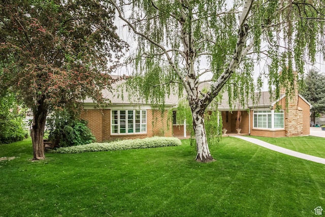 view of front of home with a front yard and brick siding