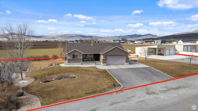 10285 N 7600 W, Tremonton, UT 84337 - single story home with a front lawn, a mountain view, a garage, and aphalt driveway