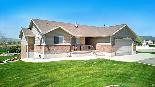 10285 N 7600 W, Tremonton, UT 84337 - ranch-style home with a front yard, a garage, brick siding, and driveway