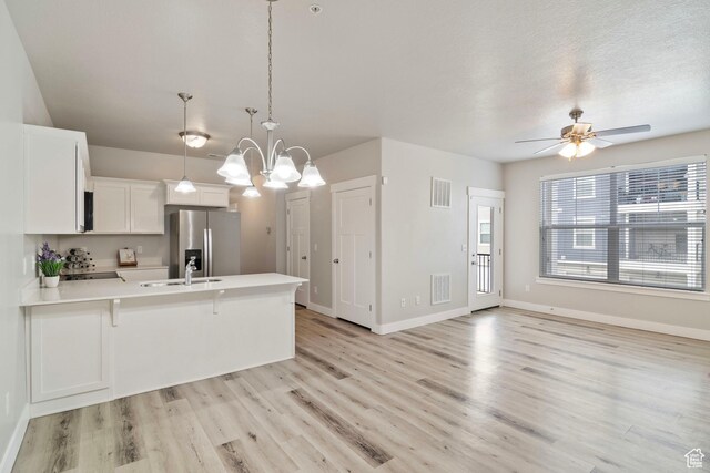 14648 S Mckellen Dr W Unit B203, Herriman, UT 84096 - kitchen featuring stainless steel fridge, a peninsula, white cabinets, light wood-type flooring, and light countertops
