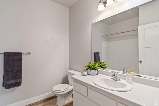 14648 S Mckellen Dr W Unit B203, Herriman, UT 84096 - bathroom featuring wood finished floors, toilet, vanity, a shower, and baseboards
