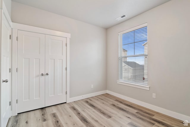 14648 S Mckellen Dr W Unit B203, Herriman, UT 84096 - unfurnished bedroom featuring baseboards, light wood finished floors, and a closet