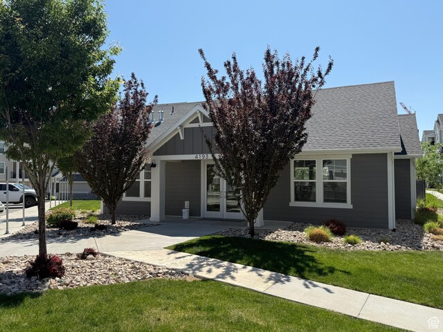 14648 S Mckellen Dr W Unit B203, Herriman, UT 84096 - view of front of home with roof with shingles, french doors, and a front lawn