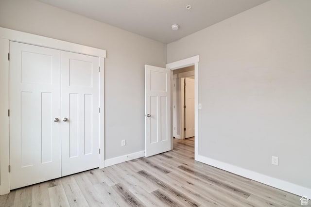 14648 S Mckellen Dr W Unit B203, Herriman, UT 84096 - unfurnished bedroom with light wood finished floors, baseboards, and a closet