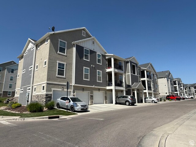 14648 S Mckellen Dr W Unit B203, Herriman, UT 84096 - view of building exterior with a garage, a residential view, and driveway