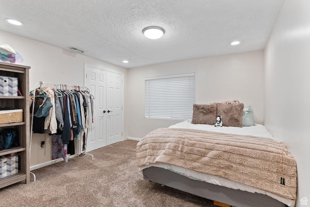 bedroom featuring visible vents, a textured ceiling, recessed lighting, a closet, and carpet floors