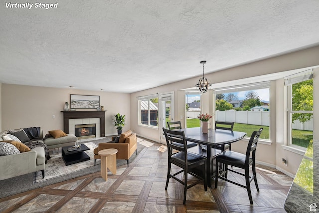 11732 S Lampton View Dr W, South Jordan, UT 84095 - dining space with a textured ceiling, a tiled fireplace, baseboards, and a chandelier