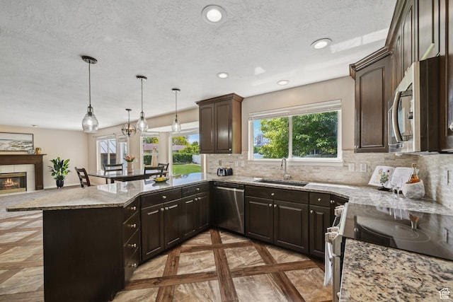 11732 S Lampton View Dr W, South Jordan, UT 84095 - kitchen featuring stainless steel appliances, a sink, a textured ceiling, a peninsula, and backsplash