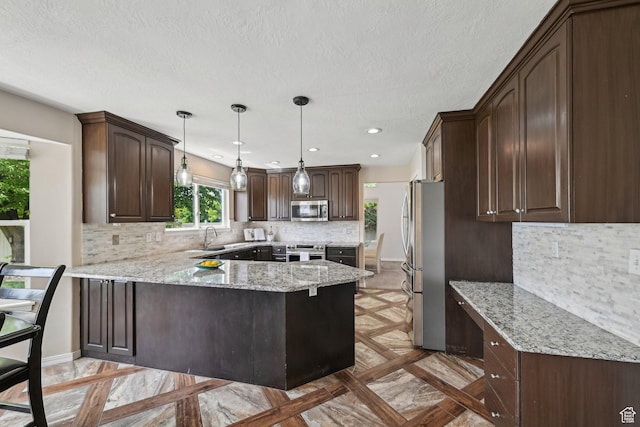 11732 S Lampton View Dr W, South Jordan, UT 84095 - kitchen with appliances with stainless steel finishes, a peninsula, dark brown cabinets, tasteful backsplash, and a sink