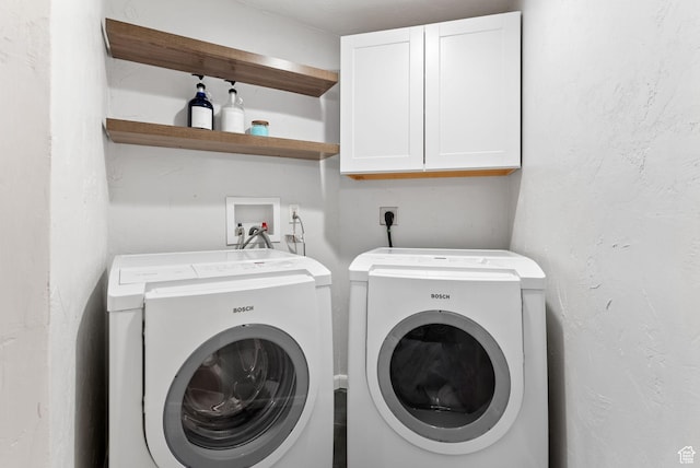 laundry room with cabinet space, washing machine and dryer, and a textured wall
