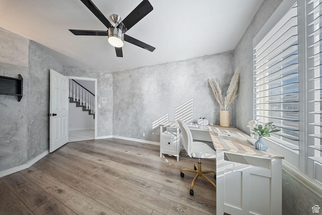 office area featuring baseboards, ceiling fan, and wood finished floors