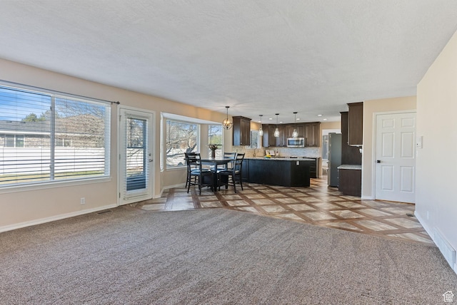 interior space featuring light colored carpet, recessed lighting, baseboards, and a textured ceiling