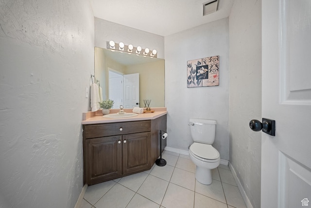 bathroom featuring visible vents, baseboards, toilet, tile patterned floors, and vanity