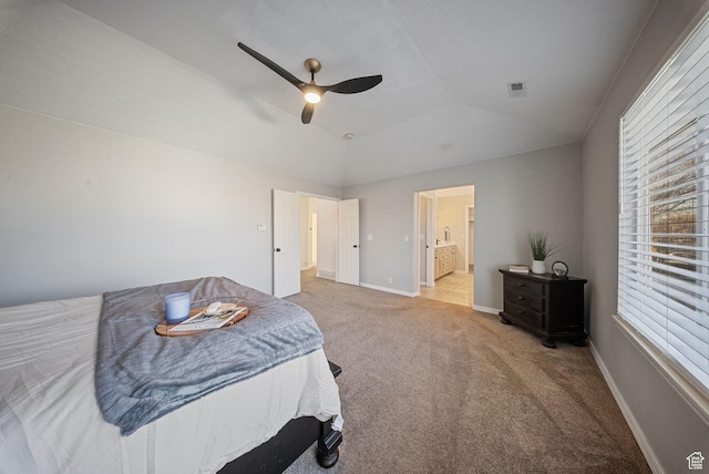 carpeted bedroom with lofted ceiling, connected bathroom, baseboards, and ceiling fan