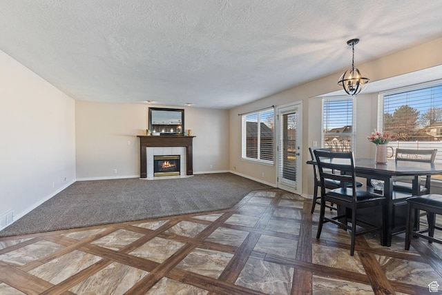 dining area featuring a wealth of natural light, a tile fireplace, and baseboards
